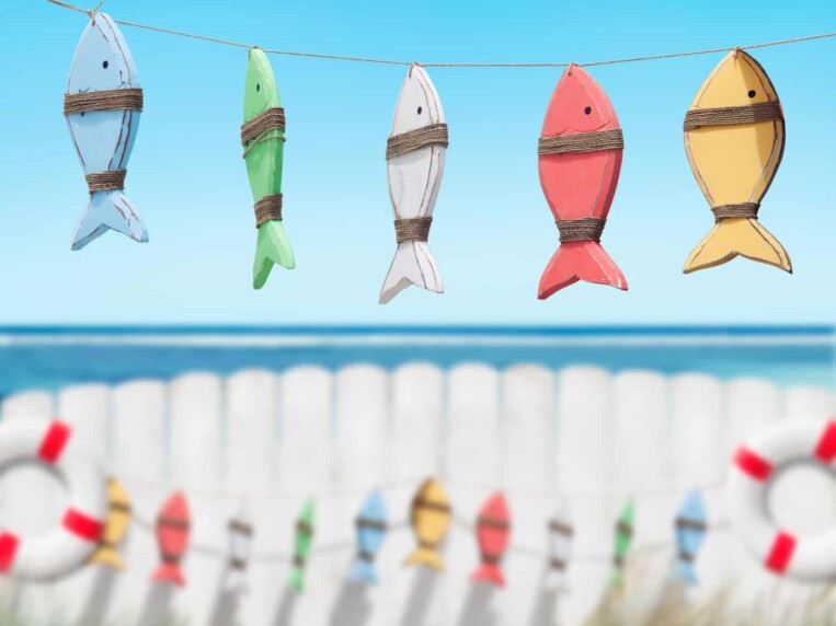 decorazioni in legno colorate a forma di pesce in spiaggia